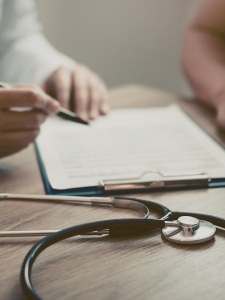 Médecin traitant remplissant un dossier médical lors d’une consultation